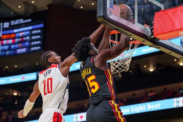 Atlanta Hawks center Clint Capela, right, goes up for a slam dunk guarded by Washington Wizards forward Alexandre Sarr, left, during the first half of an Emirates NBA Cup basketball game, Friday, Nov. 15, 2024, in Atlanta. (AP Photo/Jason Allen)