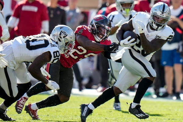 Las Vegas Raiders running back Sincere McCormick (28) runs against Tampa Bay Buccaneers safety Christian Izien (29) during the first half of an NFL football game, Sunday, Dec. 8, 2024, in Tampa, Fla. (AP Photo/Chris O'Meara)