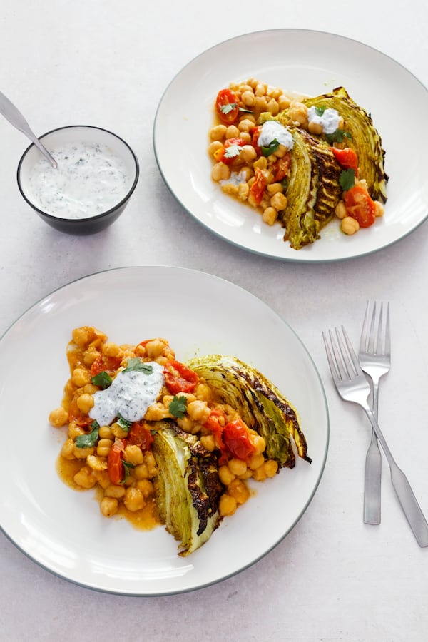 Curry-roasted cabbage wedges with tomatoes and chickpeas highlights the meaty nature of cabbage. Courtesy of America’s Test Kitchen