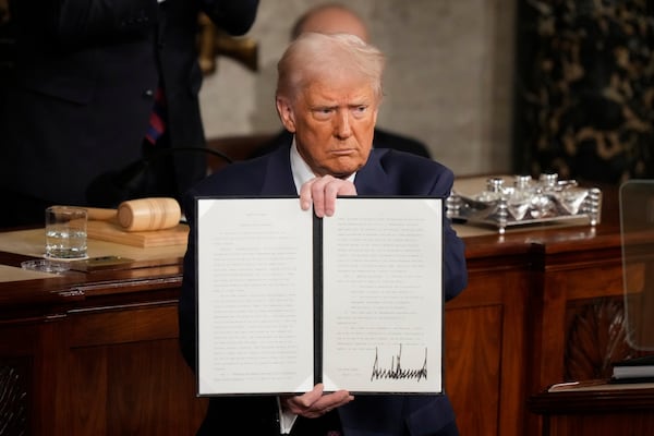 President Donald Trump held up a signed executive order as he addressed a joint session of Congress at the Capitol in Washington, Tuesday.