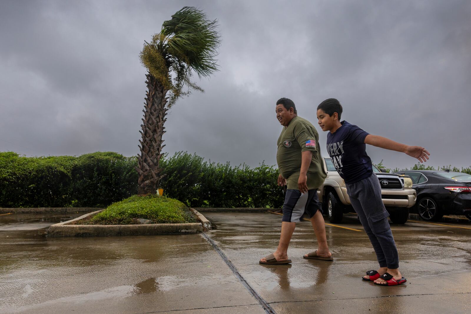 Lazaro Cardoso, 11, leans far into the powerful winds coming from the eye wall of Hurricane Francine as he and his dad, Hugo Gonzales, stay at a hotel Wednesday, Sept. 11, 2024, in Houma, La., that was being powered by a generator. The family lives not far from the hotel but they decided to stay at it since they said they always lose power during powerful storms. (Chris Granger/The Times-Picayune/The New Orleans Advocate via AP)