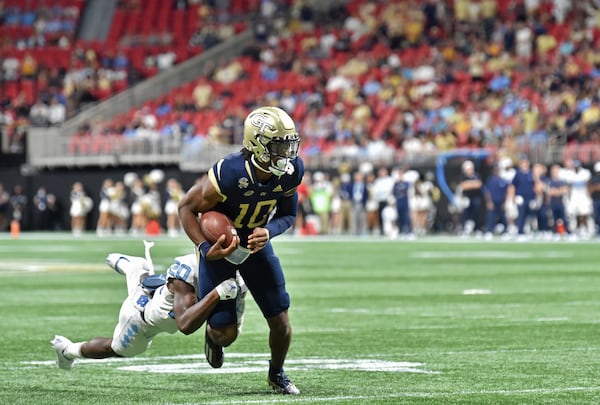 Georgia Tech quarterback Jeff Sims (10) gets tackled from behind by North Carolina defensive back Tony Grimes (20) during the second half Saturday, Sept. 25, 2021, at Mercedes-Benz Stadium in Atlanta. Tech won 45-22. (Hyosub Shin / Hyosub.Shin@ajc.com)