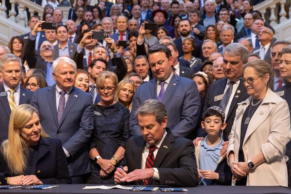 Gov. Brian Kemp signs into law an antisemitism measure, House Bill 30,  during a ceremony Wednesday at the Capitol in Atlanta. (Arvin Temkar / arvin.temkar@ajc.com)