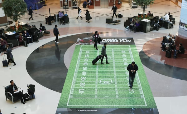 Passengers cross a football field in the Atlanta airport atrium, Bob Andres / bandres@ajc.com