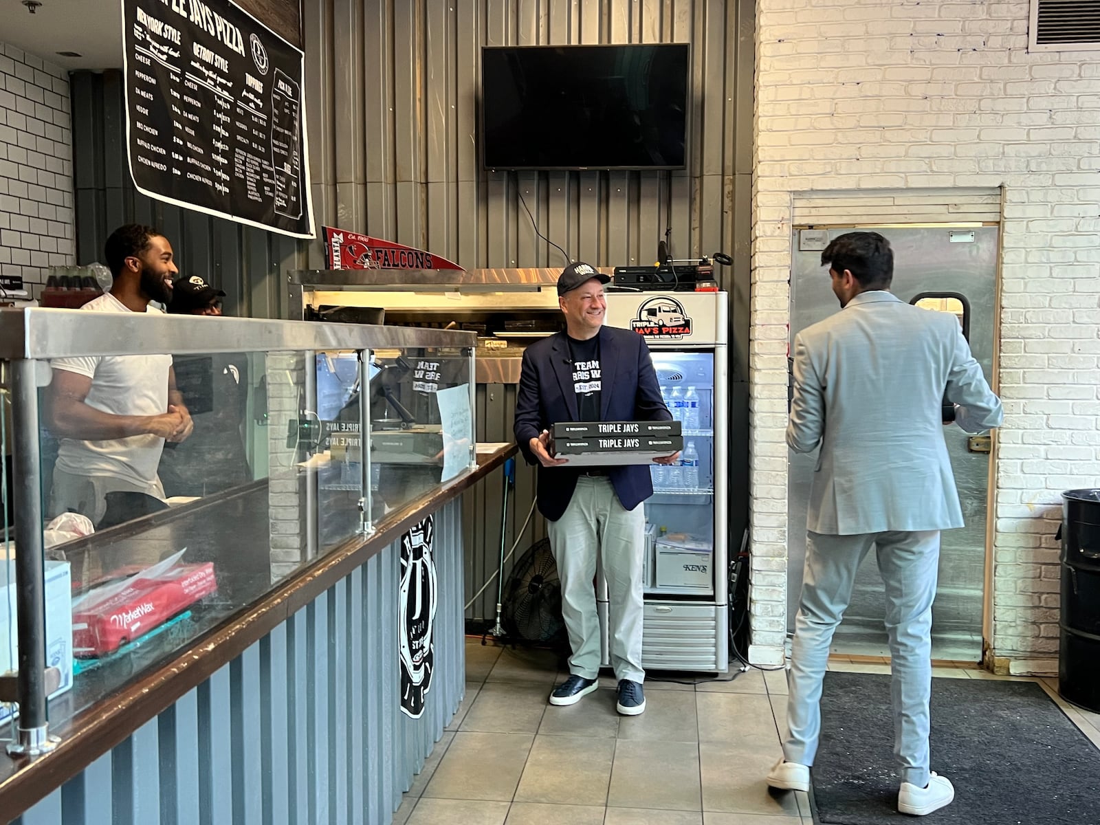 Doug Emhoff takes out four cheese and two pepperoni pizzas at Triple Jays Pizza Bar in midtown Atlanta on October 27, 2024.