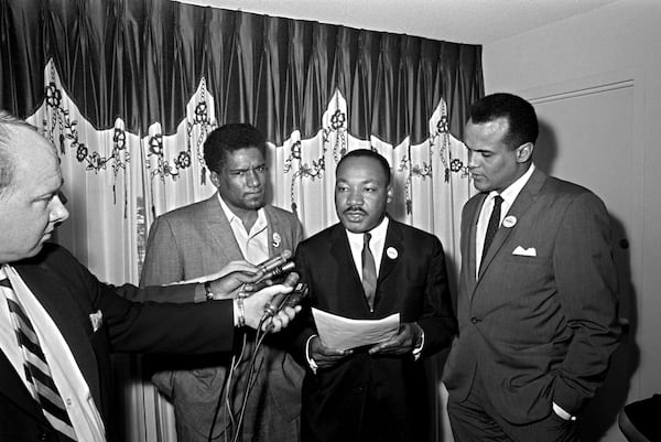 Two prominent civil rights leaders denied any disunity in their ranks and announced that their organizations will cooperate on future projects in Atlanta, April 30, 1965. At the left is James Foreman, executive secretary of the Student Non-violent Coordinating Committee. Dr. Martin Luther King Jr., center, heads the Southern Christian Leadership Conference. Singer Harry Belafonte, right, was an objective observer. King and Foreman said they would continue to work together despite differences of opinion. (AP Photo/Horace Cort)