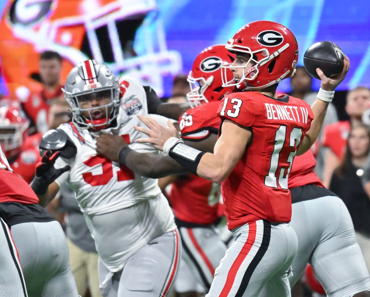 Georgia Bulldogs quarterback Stetson Bennett (13) tries to pass under pressure at the end of the second quarter of the College Football Playoff Semifinal between the Georgia Bulldogs and the Ohio State Buckeyes at the Chick-fil-A Peach Bowl In Atlanta on Saturday, Dec. 31, 2022. (Hyosub Shin / Hyosub.Shin@ajc.com)