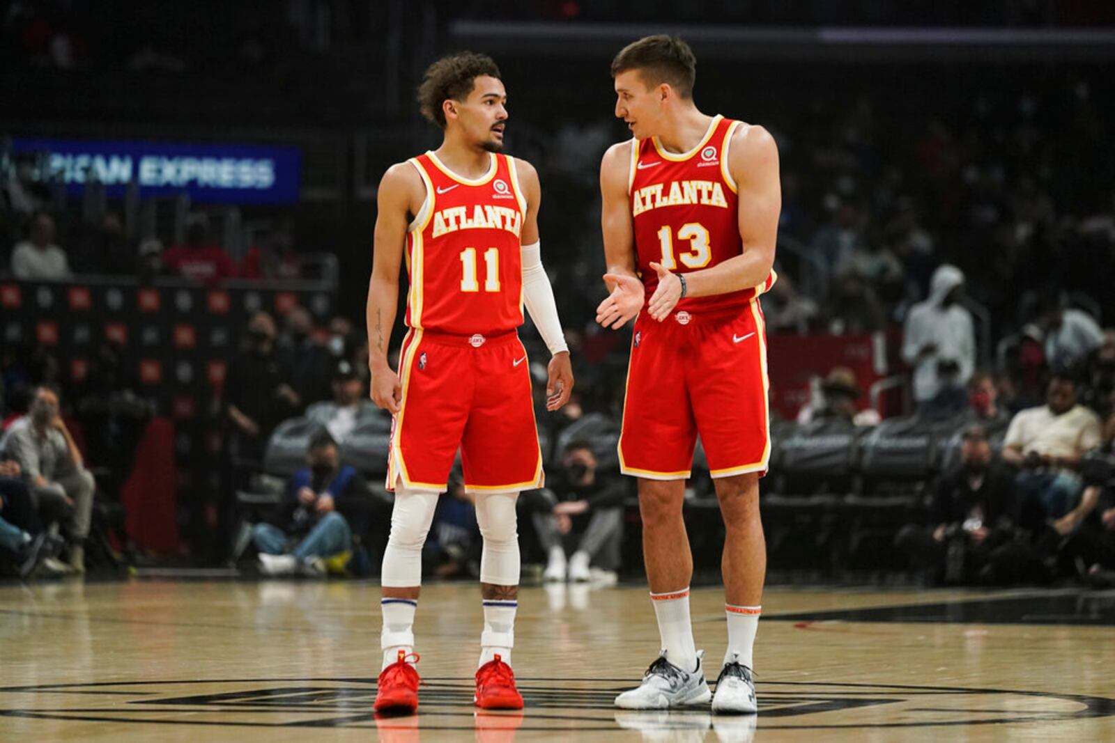 Atlanta Hawks' Trae Young, left, talks with Bogdan Bogdanovic during first half of an NBA basketball game against the Los Angeles Clippers Sunday, Jan. 9, 2022, in Los Angeles. (AP Photo/Jae C. Hong)