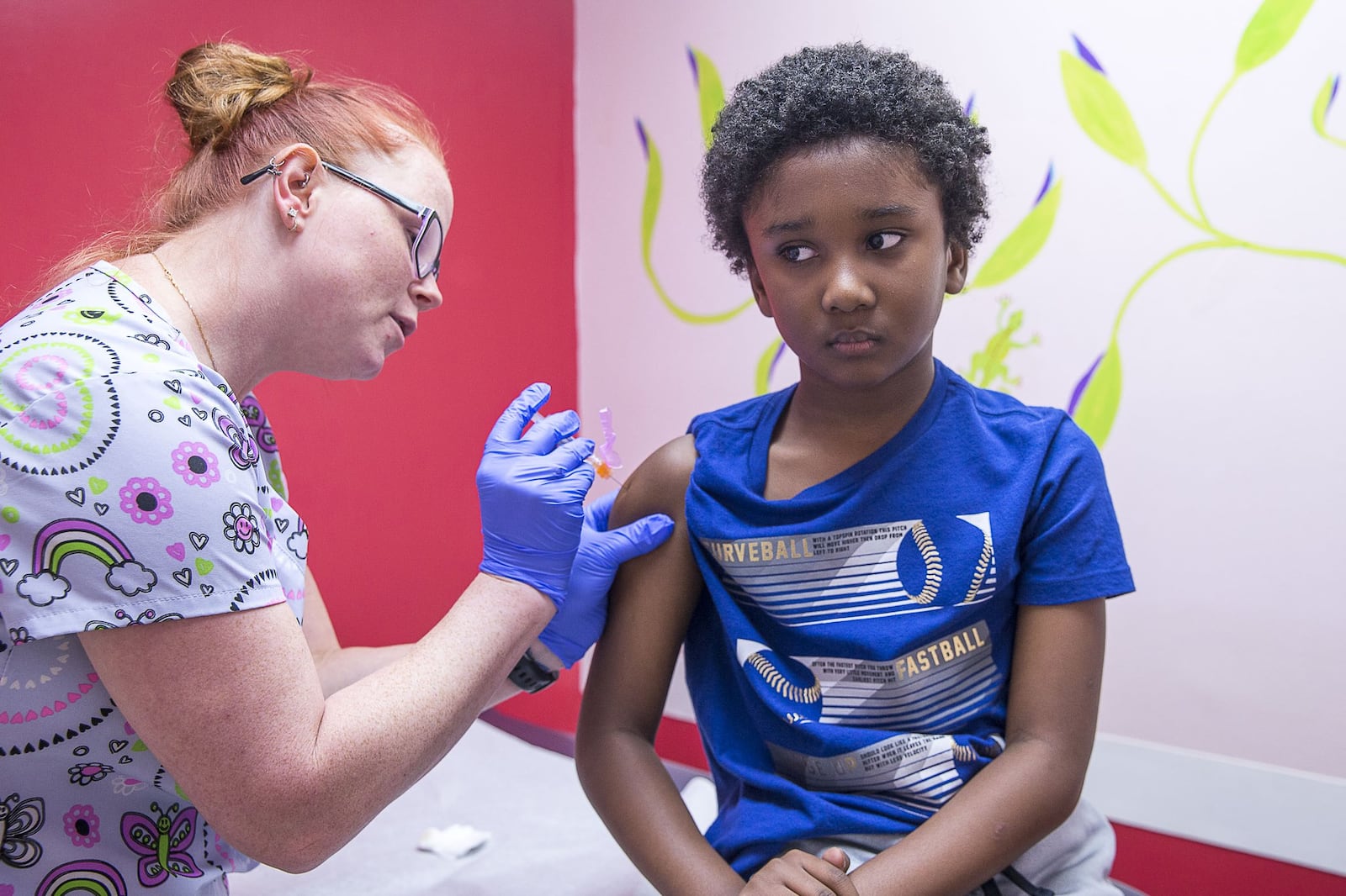 Logan Edwards, 7, of Conyers, receives an flu vaccine shot from Katie Childress, a licensed practical nurse, during a visit to Conyers Pediatrics in Conyers, Wednesday. (Alyssa Pointer/Atlanta Journal Constitution)