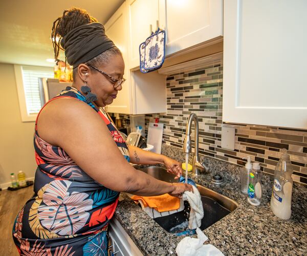 Oletha Fraser is in her kitchen in Atlanta on Wednesday, May 17, 2023 where she has lived since September.  Fraser has lived in her car, in hotels and is now cooking in her kitchen and working on her side job in her living room.  (Jenni Girtman for The Atlanta Journal-Constitution)