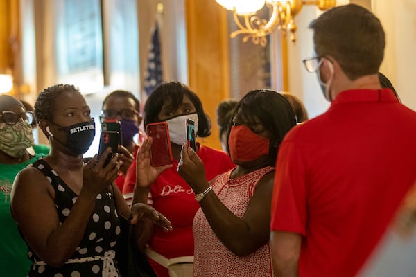 07/23/2020 - Atlanta, Georgia - Michelle Sheffield (left) of Snellville speaks to Cody Hall (right), press secretary for Gov. Brian Kemp, as she and others ask about the governors move to not mandate masks statewide and his lawsuit filed against Atlanta Mayor Keisha Lance Bottoms during a visit to the Georgia State Capitol Building in Atlanta, Thursday, July 23, 2020. (ALYSSA POINTER / ALYSSA.POINTER@AJC.COM)