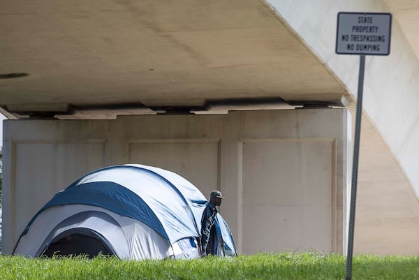 04/01/2020 - Atlanta, Georgia  - A man peeks out of his tent located below an interstate underpass on Pryor Street SW in Atlanta, Wednesday, April 1, 2020. "Tent-Cities" are popping back up due to homeless shelters at capacity or that are refusing intake due to coronavirus. (ALYSSA POINTER / ALYSSA.POINTER@AJC.COM)