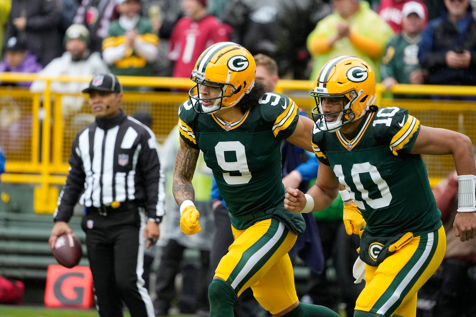 Green Bay Packers wide receiver Christian Watson (9) and quarterback Jordan Love (10) run to the bench after Watson's 44-yard reception for a touchdown during the first half of an NFL football game against the Arizona Cardinals, Sunday, Oct. 13, 2024, in Green Bay. (AP Photo/Morry Gash)