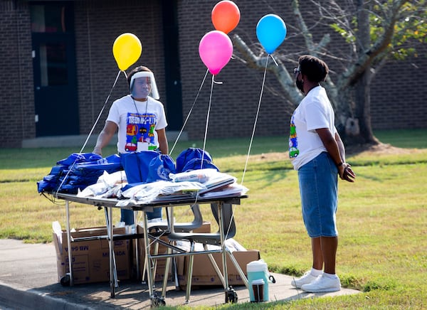 Fourth great teachers Veronica Williams, left, and Cheryl Long wait for cars to hand out free school supplies at Kemp Elementary in Hampton, Georgia on August 8, 2020.  STEVE SCHAEFER FOR THE ATLANTA JOURNAL-CONSTITUTION