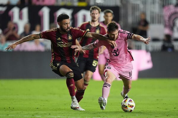 Inter Miami forward Lionel Messi (10) and Atlanta United defender Derrick Williams (3) go after the ball during the first half of an MLS playoff opening round soccer match, Saturday, Nov. 9, 2024, in Fort Lauderdale, Fla. (AP Photo/Rebecca Blackwell)