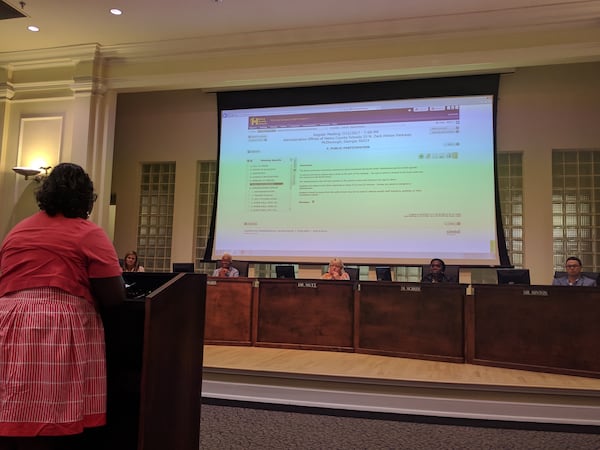 Members of the Henry County Board of Education listen to citizens express concerns over contract negotiations with superintendent candidate Dr. Timothy Gadson. AJC staff photo