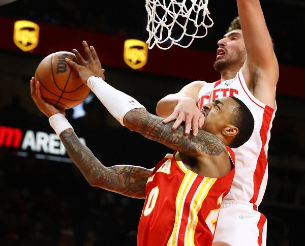 Hawks forward John Collins is fouled by Houston Rockets center Alperen Sengun on his way to the basket in a NBA basketball game on Monday, Dec 13, 2021, in Atlanta.   Curtis Compton / Curtis.Compton@ajc.com`