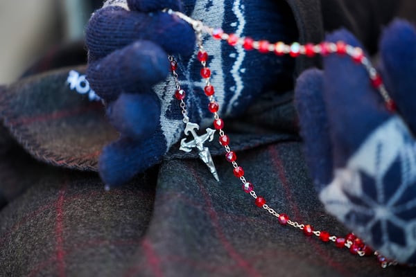 Sister JoAnn Persch, 90, a nun with the Sisters of Mercy, holds a rosary as she prays with others during a vigil outside a United States Customs and Immigration Enforcement detention facility Friday, Feb. 21, 2025, in Broadview, Ill. (AP Photo/Erin Hooley)