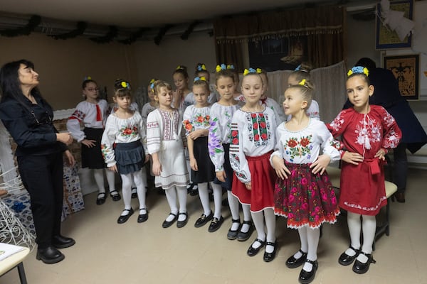 Schoolgirls in national suits perform during opening ceremony for a St. Nicholas Residence and Workshop of Good Deeds in a basement bomb shelter of a military lyceum on World Children's Day in Kyiv, Ukraine, Wednesday, Nov. 20, 2024. (AP Photo/Efrem Lukatsky)