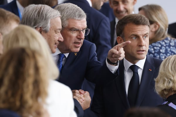 FILE - From left, United Nations' Secretary-General Antonio Guterres, the President of the International Olympic Committee (IOC) Thomas Bach and French President Emmanuel Macron speak, as they arrive, in Paris, France, for the opening ceremony of the 2024 Summer Olympics, Friday, July 26, 2024. (Ludovic Marin/Pool Photo via AP, File)