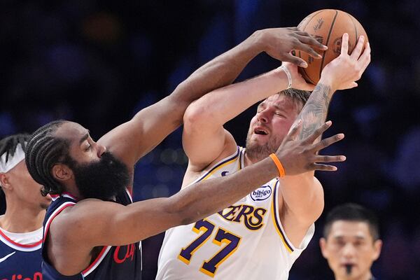 Los Angeles Lakers guard Luka Doncic, right, tries to pass while under pressure from Los Angeles Clippers guard James Harden during the first half of an NBA basketball game Sunday, March 2, 2025, in Los Angeles. (AP Photo/Mark J. Terrill)