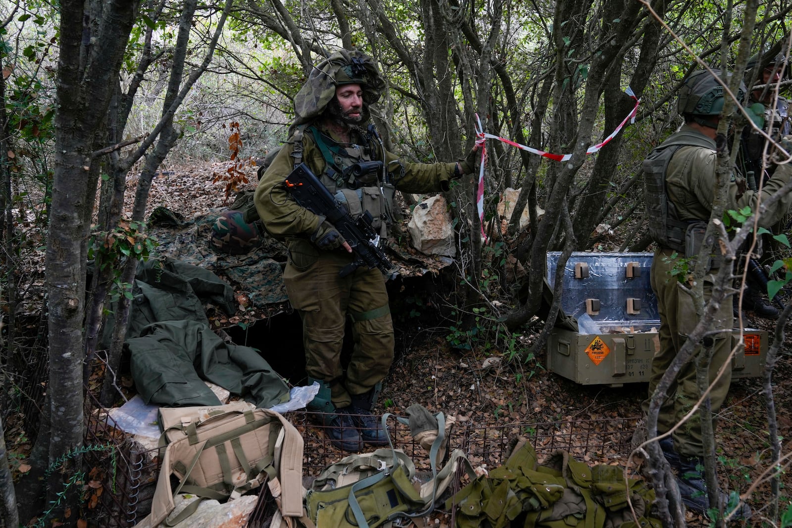 Israeli soldiers display what they say are Hezbollah ammunition and explosives found during their ground operation in southern Lebanon, near the border with Israel, Sunday, Oct. 13, 2024. (AP Photo/Sam McNeil)