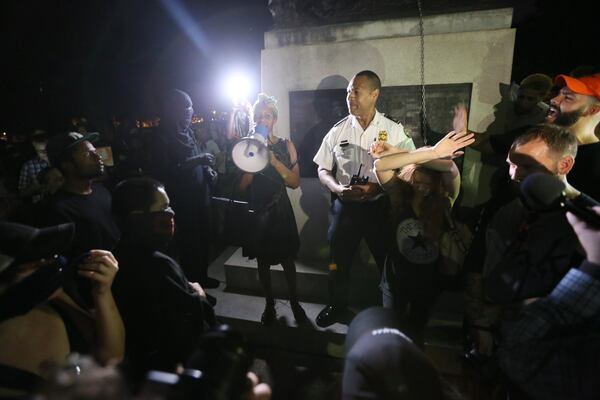 Anti-fascists and other protesters surround an Atlanta police officer Sunday evening at an anti-white nationalist rally in Piedmont Park. MIGUEL MARTINEZ / MUNDO HISPANICO