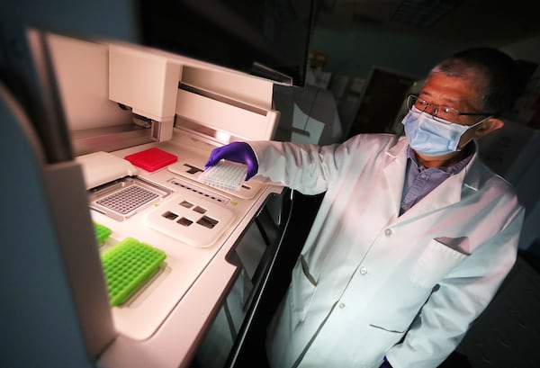 Director Jin-Xiong She works in the genomics core laboratory placing a RNA template in a newly installed Ion Chef System beside a new Ion Gene Studio S5 Prime Semiconductor Sequencer at Augusta University Medical Center. (Curtis Compton / Curtis.Compton@ajc.com)