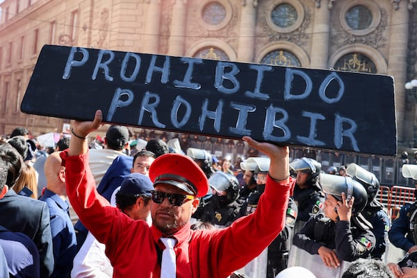 A supporter of bullfighting holds a sign that reads in Spanish "Prohibited to forbid" outside Mexico's City's Congress where lawmakers are expected to debate the continuation of bullfighting in Mexico City, Tuesday, March 18, 2025. (AP Photo/Ginnette Riquelme)