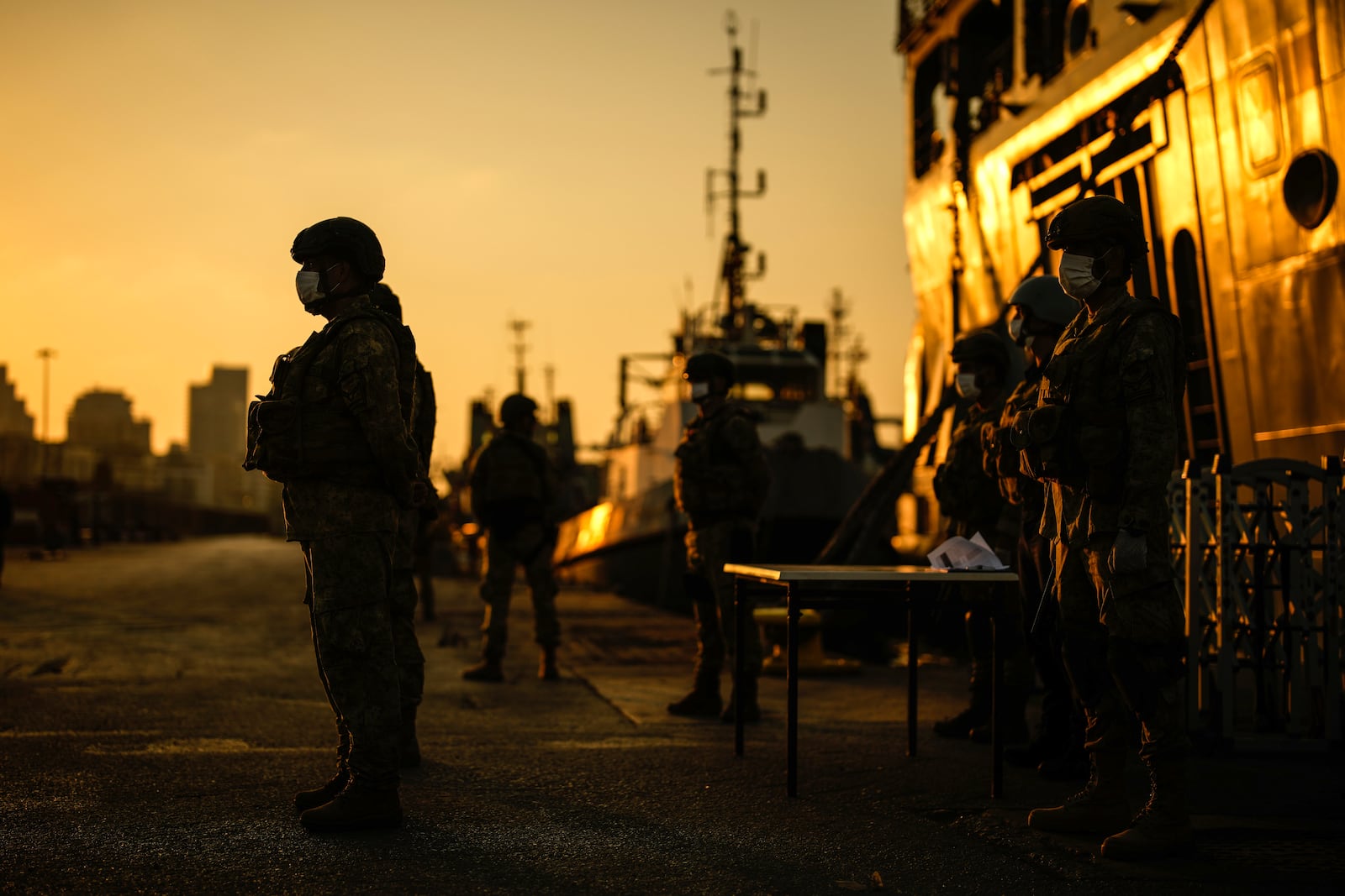 Turkish security officials stand guard next to Turkish military ships preparing to evacuate citizens from Lebanon to Turkey in Beirut port, Wednesday, Oct. 9, 2024. (AP Photo/Emrah Gurel)