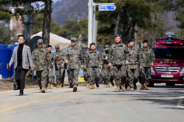 Military soldiers walk out from the scene where a South Korean fighter jet accidentally dropped bombs on a civilian area during training, in Pocheon, South Korea, Thursday, March 6, 2025. (AP Photo/Lee Jin-man)