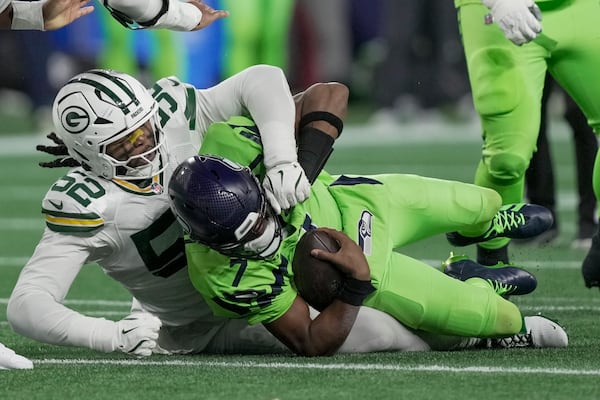 Green Bay Packers' Rashan Gary sacks Seattle Seahawks' Geno Smith during the first half of an NFL football game Sunday, Dec. 15, 2024, in Seattle. (AP Photo/Stephen Brashear)