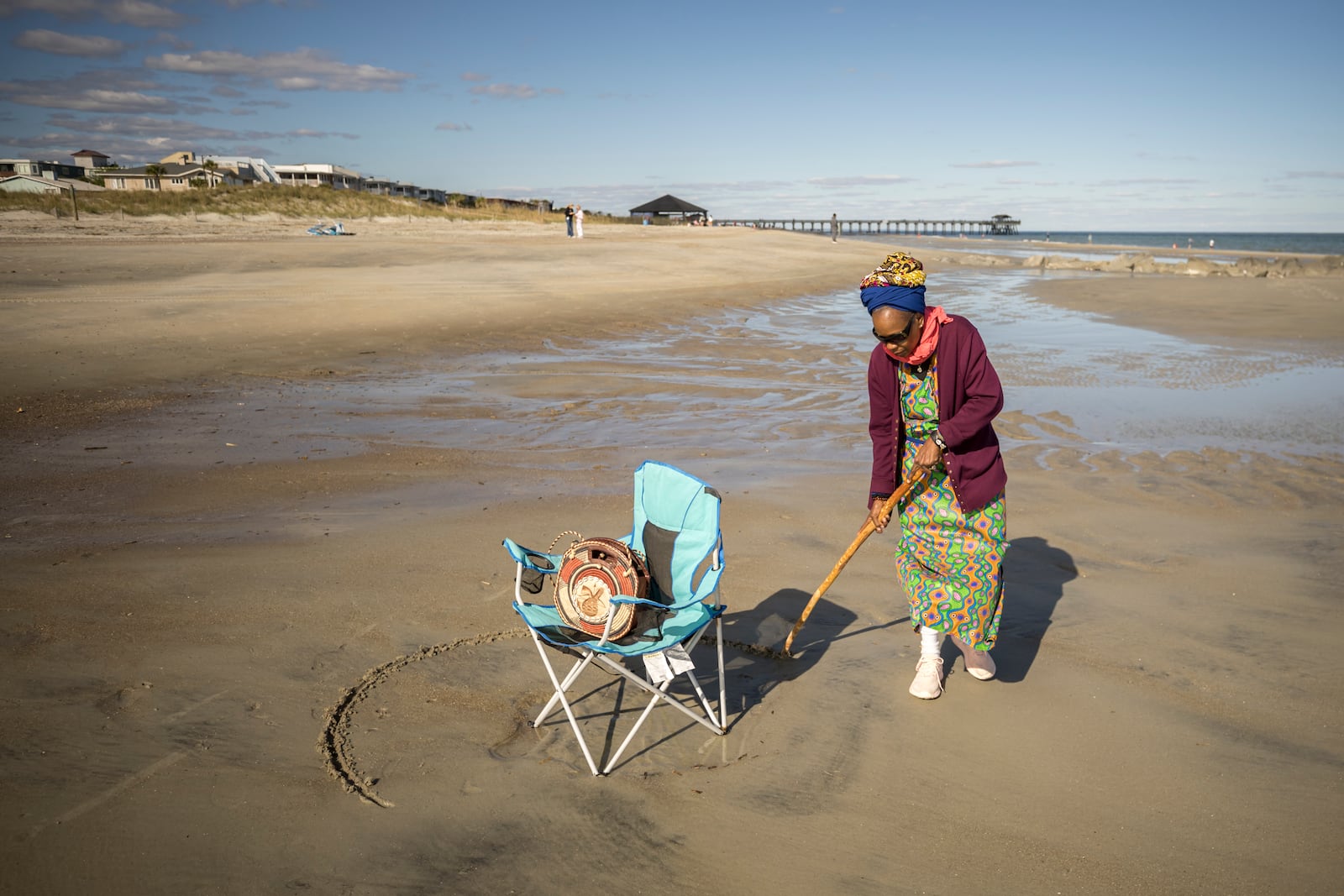 Julia Pearce, who's running for may of Tybee Island, draws a full circle around her beach chair as an invitation for friends to join her spot on the beach. Pearce is a well-known activist for the island's Black history, and she said she draws a circle as an acknowledgment to her community and her ancestors. (AJC Photo/Stephen B. Morton)