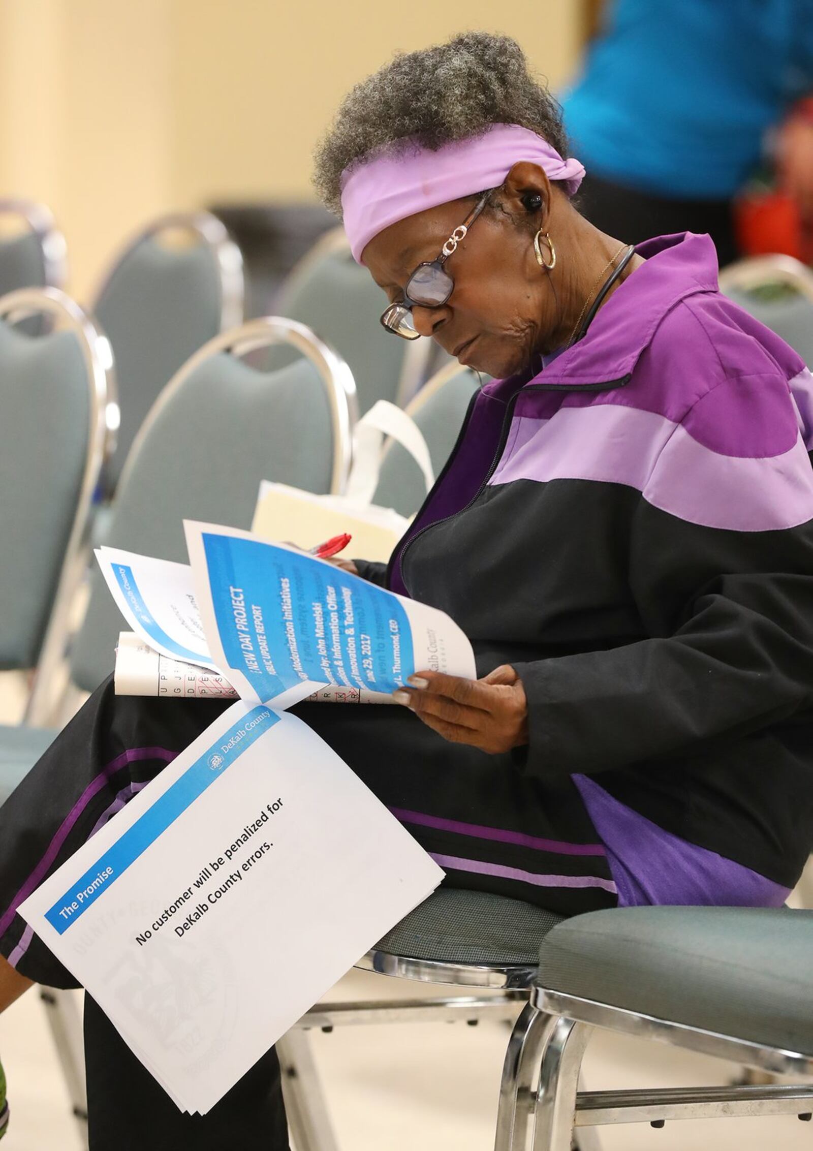 Toby Jennings of Lithonia, whose current water bill is $2009.49, looks over the meeting program while DeKalb CEO Mike Thurmond updates residents about the depth of the county’s remaining water billing problems during his third public update on Thursday in Decatur. Curtis Compton/ccompton@ajc.com