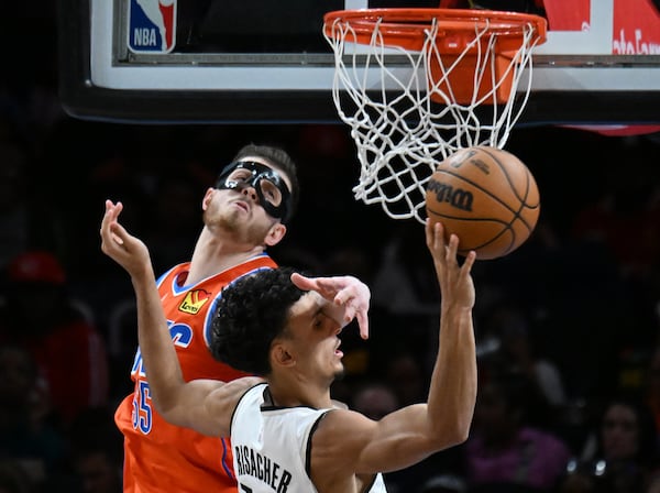 Atlanta Hawks forward Zaccharie Risacher goes to the basket as Oklahoma City Thunder center Isaiah Hartenstein (left) blocks during the second half in an NBA basketball game at State Farm Arena, Friday, February 28, 2025, in Atlanta. Oklahoma City Thunder won 135-119 over Atlanta Hawks. (Hyosub Shin / AJC)