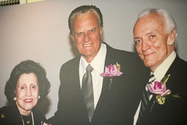 A photo of the Rev. Henry Holley (right) and his wife, Bettie, with Billy Graham hangs on the wall at Holley’s home. ALYSSA POINTER / ALYSSA.POINTER@AJC.COM