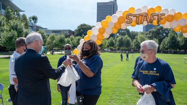 Georgia Tech President Angel Cabrera, dressed in a dark blazer, talks to employees during staff appreciation event on its campus. Georgia Tech has held more such wellness events, particularly for mental health counselors dealing with various forms of stress. PHOTO CONTRIBUTED.