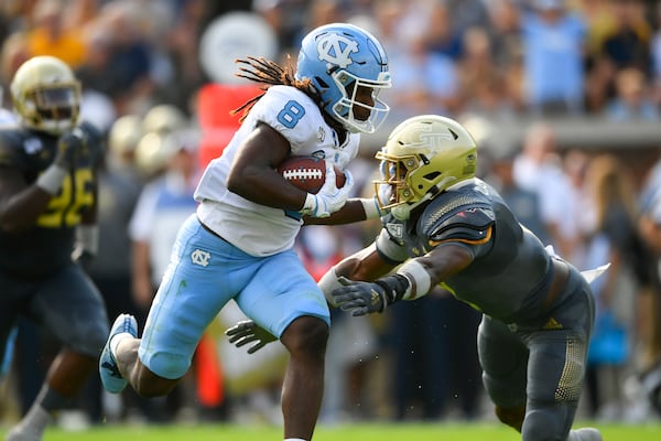 North Carolina running back Michael Carter (8) is tackled by  Georgia Tech defensive back Tariq Carpenter Saturday, Oct. 5, 2019, in Atlanta. North Carolina won 38-22. (John Amis/For the AJC)