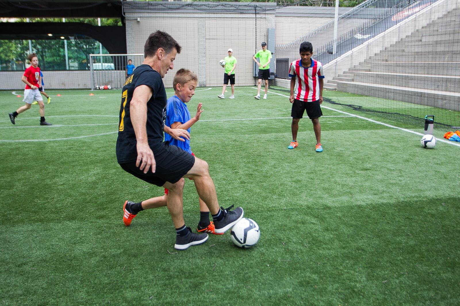 Phil Hill, executive director of Soccer in the Streets, mixes it up with kids at a summer camp at the Five Points MARTA Station. 