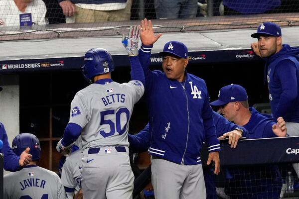 Los Angeles Dodgers' Mookie Betts (50) celebrates with manager Dave Roberts after hitting a sacrifice fly against the New York Yankees during the eighth inning in Game 5 of the baseball World Series, Wednesday, Oct. 30, 2024, in New York. (AP Photo/Seth Wenig)