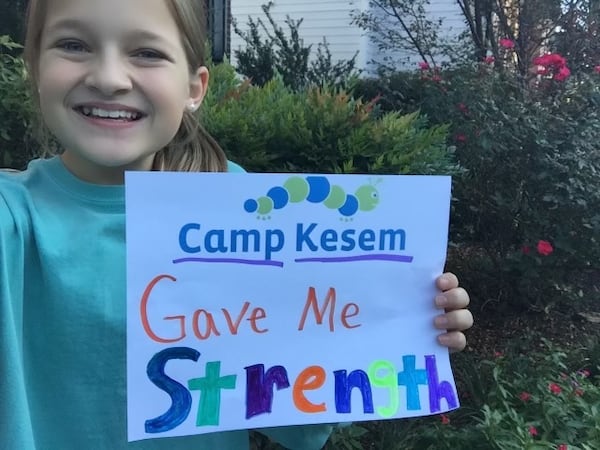 Leah Banko holds a Camp Kesem sign as a child. Kesem provides a week of free, overnight summer camp designed to empower campers who have been impacted by a parent’s cancer and create a fun and supportive community. (Courtesy of Leah Banko)