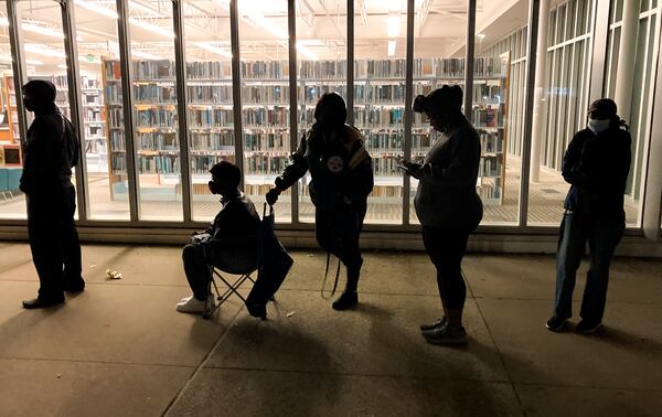 A line forms at 6:30 outside the Metropolitan Library as people wait for the doors to open on the last day of early voting, Friday, Dec. 2, 2022.  (Steve Schaefer/steve.schaefer@ajc.com)