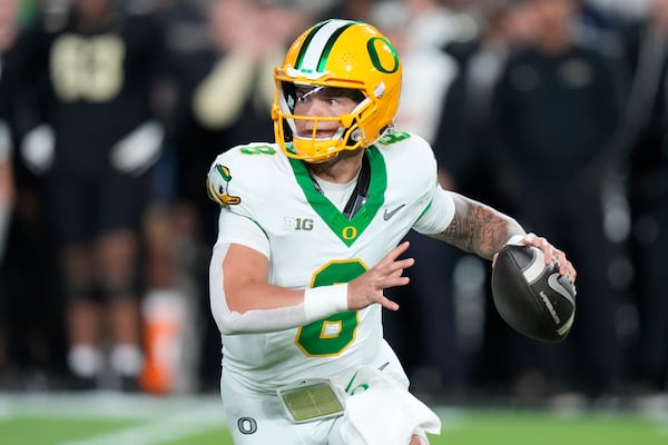 FILE - Oregon quarterback Dillon Gabriel (8) looks to pass while playing Purdue during the first half of an NCAA college football game in West Lafayette, Ind., Friday, Oct. 18, 2024. (AP Photo/AJ Mast, File)