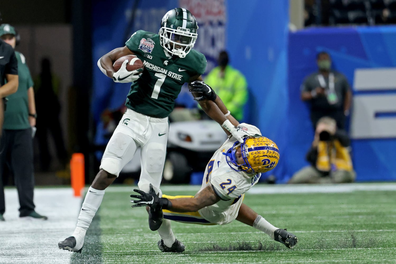 Michigan State Spartans wide receiver Jayden Reed (1) stiff arms Pittsburgh Panthers defensive back Tamarion Crumpley (24) after a catch in the fourth quarter of the Chick-fil-A Peach Bowl at Mercedes-Benz Stadium in Atlanta, Thursday, December 30, 2021. JASON GETZ FOR THE ATLANTA JOURNAL-CONSTITUTION