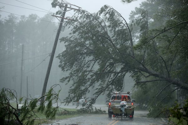  A volunteer rescue truck drives underneath a fallen tree that is suspended by power lines blown down by Hurricane Florence on Friday in New Bern, N.C.   (Photo: Chip Somodevilla/Getty Images)