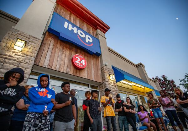 Family and friends mourn the loss of 16-year-old Jacob Johnson at a candlelight vigil outside a DeKalb County IHOP.