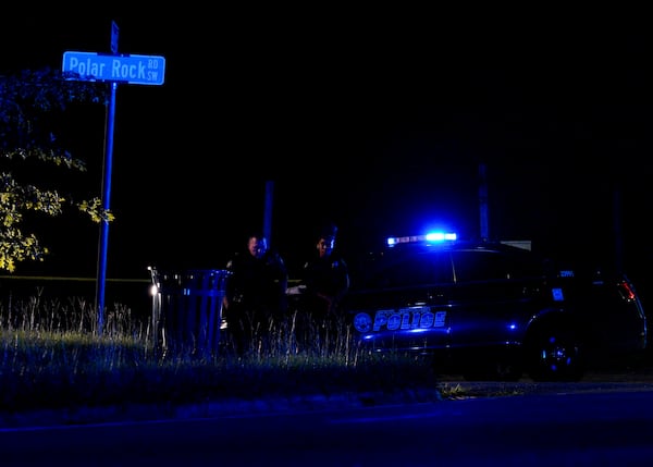 Atlanta police officers stand outside the scene of an officer-involved shooting. A woman accused of critically wounding a Clayton County police officer was struck multiple times when Atlanta police officers opened fire, according to police.