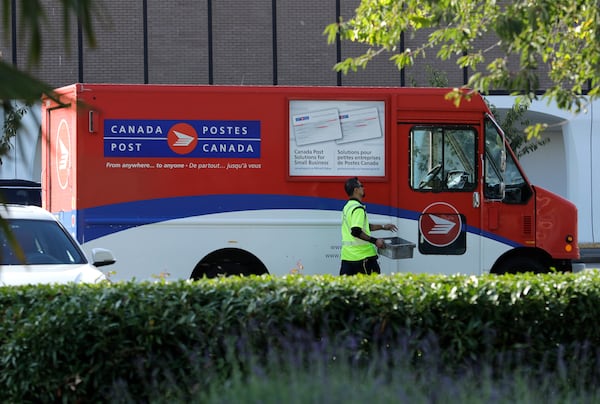 FILE -A Canada Post worker walks to his truck on Sept. 26, 2018 in Richmond, British Columbia. (AP Photo/Ted S. Warren, File)