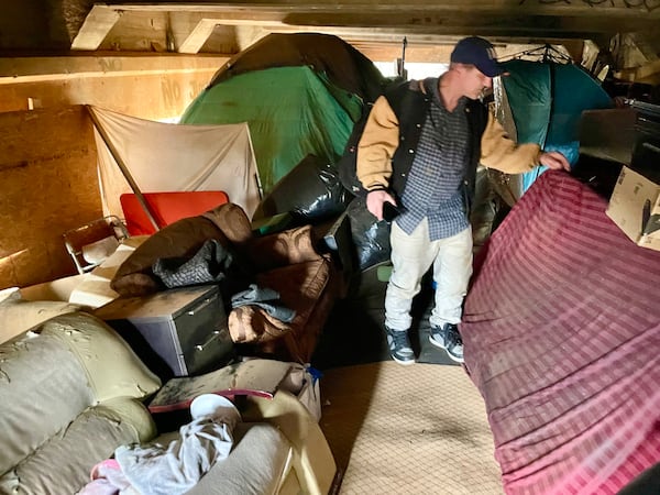 Scott Drotar inspects the interior of an elaborate  homeless encampment built  under a bridge on Cheshire Bridge. He was looking for a homeless man he had been helping.