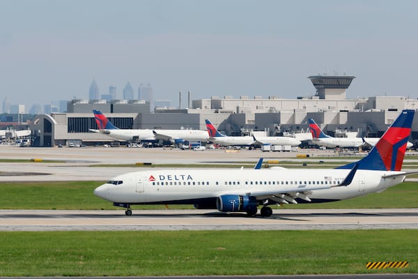 With the Atlanta skyline in the background, a Delta airplane lands at Hartsfield-Jackson International Airport on Sept. 7, 2022, in Atlanta. (Jason Getz/The Atlanta Journal-Constitution/TNS)